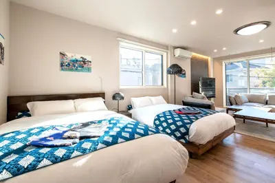 a bedroom with two beds and a living room at Ciel\u5357\u9ebb\u5e03 in Tokyo