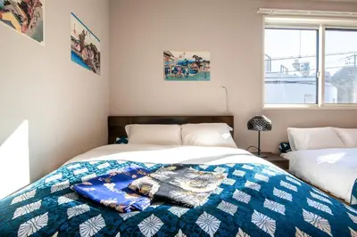 a bedroom with two beds with a blue and white blanket at Ciel\u5357\u9ebb\u5e03 in Tokyo