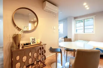a living room with a table and a mirror at Ciel\u5357\u9ebb\u5e03 in Tokyo