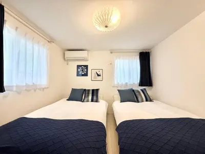 two beds in a small room with windows at Katsushika House\u67f4\u53c8 KS0340 in Tokyo
