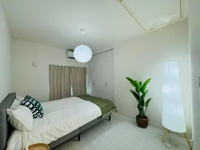 a bedroom with a bed and a plant and two lights at Ikebukuro House-TS0378 in Tokyo