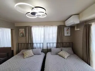 two beds in a bedroom with a ceiling fan at Jr\u5c71\u6c34\u7ebf \u99d2\u8fbc\u8f66\u7ad93\u5206\u949f \u76f4\u8fbe\u65b0\u5bbf\u6d89\u8c37\u6c60\u888b\u4e0a\u91ce\u79cb\u53f6\u539f Max5 in Tokyo