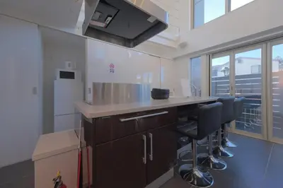 an empty kitchen with a counter and stools at \u30d7\u30e9\u30a4\u30e0\u30c6\u30e9\u30b9\u4e0a\u6c60\u53f05\u4e01\u76ee in Tokyo