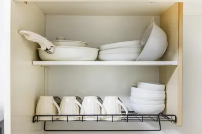 a cupboard filled with plates and bowls and dishes at \u99c5\u304b\u3089\u5f92\u6b691\u5206 \u5de3\u9d28\u99c5 \u6700\u59274\u540d \u7121\u6599wifi 45\u5e73\u7c73\u3067\u5e83\u3044\u304a\u90e8\u5c4b in Tokyo
