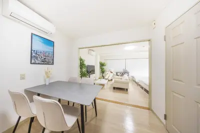 a dining room with a table and chairs and a bedroom at \u99c5\u304b\u3089\u5f92\u6b691\u5206 \u5de3\u9d28\u99c5 \u6700\u59274\u540d \u7121\u6599wifi 45\u5e73\u7c73\u3067\u5e83\u3044\u304a\u90e8\u5c4b in Tokyo