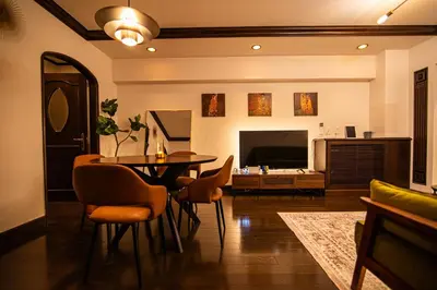 a living room with a table and chairs and a television at \u30b5\u30f3\u30e2\u30fc\u30eb\u30af\u30ec\u30b9\u30c8306 in Tokyo