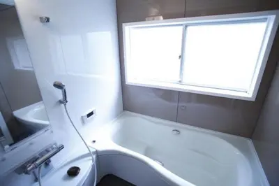 a bathroom with a tub and a sink and a window at Yanesen Traditional Nagaya house in Tokyo