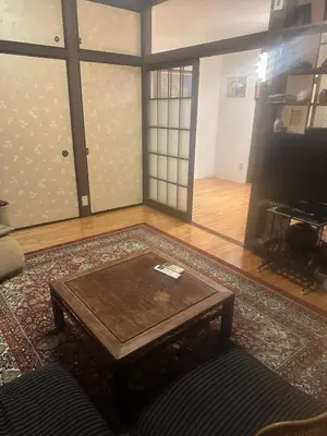 a living room with a coffee table on a rug at Yanesen Traditional Nagaya house in Tokyo