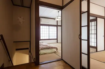 a bedroom with a mirror and a bed in a room at Yanesen Traditional Nagaya house in Tokyo