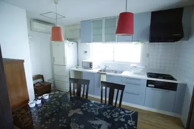 a kitchen with a table and two chairs in it at Yanesen Traditional Nagaya house in Tokyo