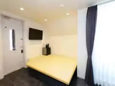 a bedroom with a yellow bed and a window at Chaan Ueno Hotel - Vacation STAY 01159v in Tokyo