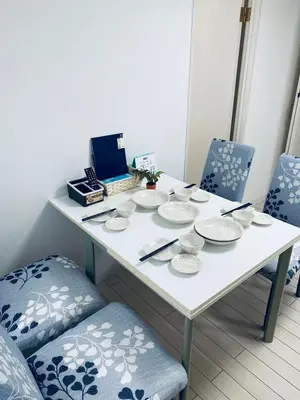 a white table with dishes on it with two chairs at \u7d50\u5948\u5e0c Yunakis House in Tokyo