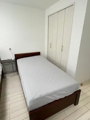a bedroom with a bed and a white cabinet at \u7d50\u5948\u5e0c Yunakis House in Tokyo
