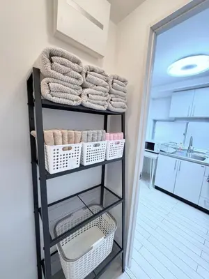 a towel rack in a bathroom with towels and baskets at \u7d50\u5948\u5e0c Yunakis House in Tokyo