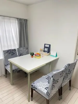 a dining room table with two chairs and a white table at \u7d50\u5948\u5e0c Yunakis House in Tokyo