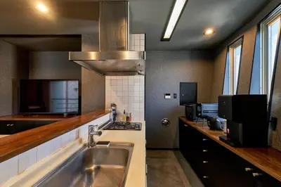 a kitchen with a stainless steel sink and a microwave at ACOE Higashi-Shinjuku Gourmet Area in Tokyo