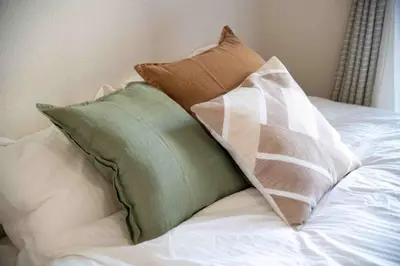 a pile of pillows sitting on top of a bed at FIKA Higashi Shinjuku in Tokyo
