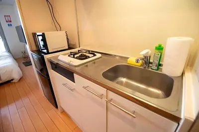 a small kitchen with a sink and a refrigerator at FIKA Higashi Shinjuku in Tokyo