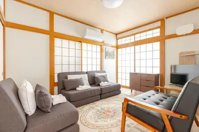 a living room with two couches and a tv at Fukurou House in Tokyo