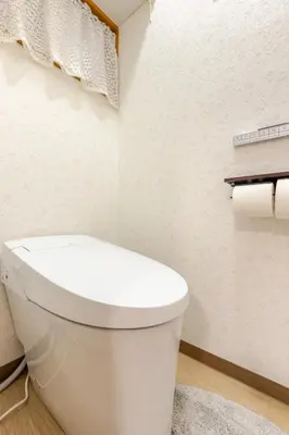 a white bathroom with a toilet and rolls of toilet paper at Fukurou House in Tokyo