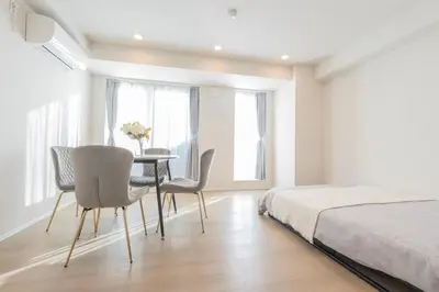 a bedroom with a table and chairs and a bed at \u6b74\u53f2\u7684\u5bfa\u9662\u8fd1\u304f \u89b3\u5149\u5730\u3078\u306e\u30a2\u30af\u30bb\u30b9\u4fbf\u5229 Qe in Tokyo