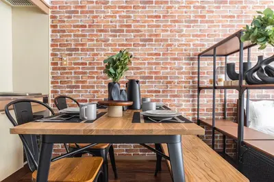 a brick wall with a wooden table and chairs at Stay Ikebukuro in Tokyo