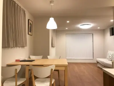 a living room with a wooden table and chairs at \u6728\u6751\u5c4b-\u6c60\u888b Kimuraya-Ikebukuro in Tokyo