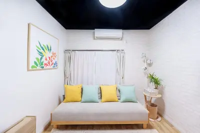 a room with a bed with yellow and blue pillows at \u697d\u9038\u30b0\u30eb\u30fc\u30d7 \u56db\u30c4\u6728 102t in Tokyo