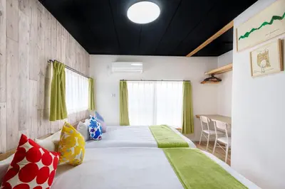 a bedroom with a large bed and a table at \u697d\u9038\u30b0\u30eb\u30fc\u30d7 \u56db\u30c4\u6728 102t in Tokyo