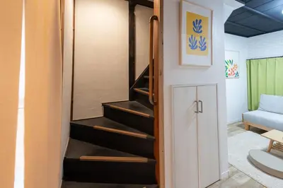 a staircase in a room with a couch at \u697d\u9038\u30b0\u30eb\u30fc\u30d7 \u56db\u30c4\u6728 102t in Tokyo