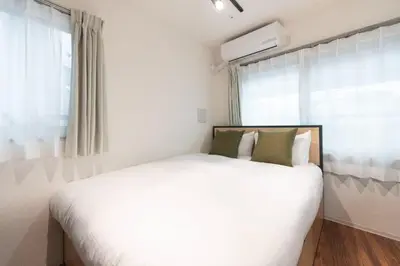 a bedroom with a white bed and a window at \u30b0\u30ec\u30a4\u30b9\u30a2\u30fc\u30b9\u30ec\u30b8\u30c7\u30f3\u30b9\u5317\u5343\u4f4f in Tokyo