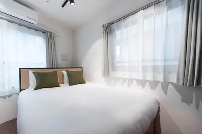 a bedroom with a white bed and a window at \u30b0\u30ec\u30a4\u30b9\u30a2\u30fc\u30b9\u30ec\u30b8\u30c7\u30f3\u30b9\u5317\u5343\u4f4f in Tokyo