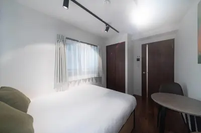 a bedroom with a bed and a table and a window at \u30b0\u30ec\u30a4\u30b9\u30a2\u30fc\u30b9\u30ec\u30b8\u30c7\u30f3\u30b9\u5317\u5343\u4f4f in Tokyo