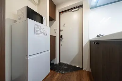 a refrigerator with a microwave on top of it in a room at \u30b0\u30ec\u30a4\u30b9\u30a2\u30fc\u30b9\u30ec\u30b8\u30c7\u30f3\u30b9\u5317\u5343\u4f4f in Tokyo