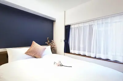 a bedroom with a large white bed with a window at \u90fd\u5fc3\u7f55\u89c1 \u79cb\u53f6\u539f\u4e1c\u4eac\u7ad9KDoa \u8d85\u7ea7\u5962\u534e\u53cc\u5367\u5957\u623f\u5e26\u53a8\u623f \u5730\u94c13\u5206\u949f \u6234\u68eePOLA\u9876\u7ea7\u914d\u7f6e \u79cb\u53f6\u539f\u6b65\u884c\u53ef\u8fbe \u4e1c\u4eac\u7ad94\u5206\u949f in Tokyo