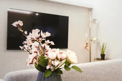 a vase filled with pink flowers in a living room at \u90fd\u5fc3\u7f55\u89c1 \u79cb\u53f6\u539f\u4e1c\u4eac\u7ad9KDoa \u8d85\u7ea7\u5962\u534e\u53cc\u5367\u5957\u623f\u5e26\u53a8\u623f \u5730\u94c13\u5206\u949f \u6234\u68eePOLA\u9876\u7ea7\u914d\u7f6e \u79cb\u53f6\u539f\u6b65\u884c\u53ef\u8fbe \u4e1c\u4eac\u7ad94\u5206\u949f in Tokyo