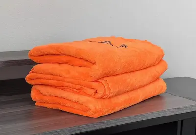 a stack of orange towels sitting on a table at \u4e0b\u6d1b\u5408\u70ed\u95e8\u7684\u65b0\u5bbf \u6700\u592712\u540d \u63d0\u4f9b\u72ec\u7acb\u623f\u5c4b Wifi\u7f51\u7edcMK535 in Tokyo