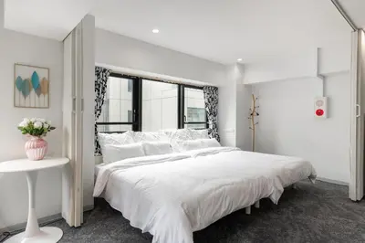 a white bedroom with a large white bed and a table at \u6771\u4eac\u30bf\u30ef\u30fc\u8fd1 \u864e\u30ce\u9580\u30d2\u30eb\u30ba\u99c5\u5f92\u6b694\u5206\u30b9\u30bf\u30a4\u30ea\u30c3\u30b7\u30e5 501 in Tokyo