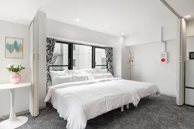 a white bedroom with a large bed and a window at \u6771\u4eac\u30bf\u30ef\u30fc\u8fd1 \u864e\u30ce\u9580\u30d2\u30eb\u30ba\u99c5\u5f92\u6b694\u5206\u30b9\u30bf\u30a4\u30ea\u30c3\u30b7\u30e5 501 in Tokyo