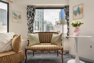 a living room with a chair and a table and a window at \u6771\u4eac\u30bf\u30ef\u30fc\u8fd1 \u864e\u30ce\u9580\u30d2\u30eb\u30ba\u99c5\u5f92\u6b694\u5206\u30b9\u30bf\u30a4\u30ea\u30c3\u30b7\u30e5 501 in Tokyo