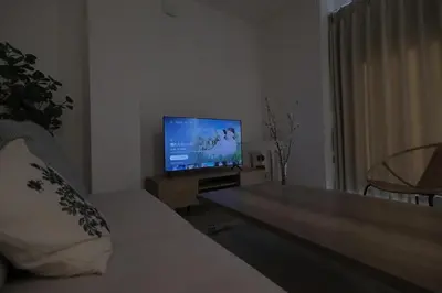 a living room with a couch and a flat screen tv at Cozy Nest Nakano 2 stops 5 min to Ikebukuro 7 stops to Shinjuku 15 min new 1LDK in Tokyo