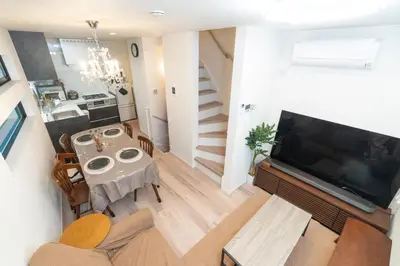 a living room with a table and a large television at RIAUS \u65b0\u7bc9\u4e00\u8ed2\u5bb6\u8cb8\u5207 \u6700\u59276\u540d family\u6b53\u8fce \u7a7a\u6e2f\u3084\u89b3\u5149\u5730\u76f4\u901a in Tokyo