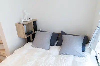 a bed with blue and white pillows in a room at RIAUS \u65b0\u7bc9\u4e00\u8ed2\u5bb6\u8cb8\u5207 \u6700\u59276\u540d family\u6b53\u8fce \u7a7a\u6e2f\u3084\u89b3\u5149\u5730\u76f4\u901a in Tokyo