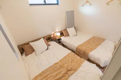 a small room with two beds and a window at RIAUS \u65b0\u7bc9\u4e00\u8ed2\u5bb6\u8cb8\u5207 \u6700\u59276\u540d family\u6b53\u8fce \u7a7a\u6e2f\u3084\u89b3\u5149\u5730\u76f4\u901a in Tokyo