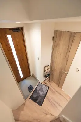 an attic room with two wooden doors and a chair at RIAUS \u65b0\u7bc9\u4e00\u8ed2\u5bb6\u8cb8\u5207 \u6700\u59276\u540d family\u6b53\u8fce \u7a7a\u6e2f\u3084\u89b3\u5149\u5730\u76f4\u901a in Tokyo