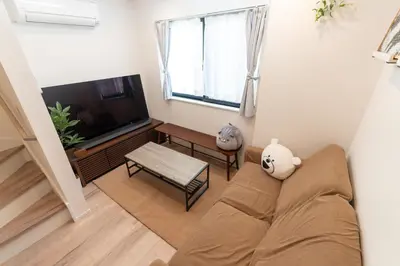 a living room with a couch and a television at RIAUS \u65b0\u7bc9\u4e00\u8ed2\u5bb6\u8cb8\u5207 \u6700\u59276\u540d family\u6b53\u8fce \u7a7a\u6e2f\u3084\u89b3\u5149\u5730\u76f4\u901a in Tokyo