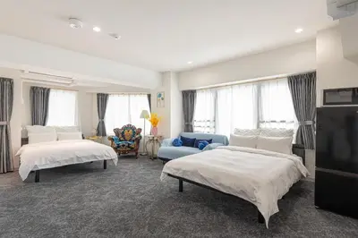a bedroom with two beds and a blue couch at \u4e1c\u4eac\u5854Toranomon Hills\u7ad9\u6b65\u884c4\u5206\u864e\u95e8701 in Tokyo