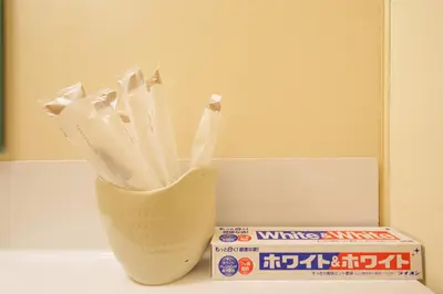 a vase with toothbrushes in it next to a box of milk at Premier suite Shinjuku okubo Tokyo 1F 2F in Tokyo