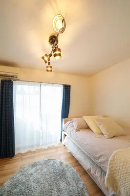 a bedroom with a bed with a ceiling fan and a window at Premier suite Shinjuku okubo Tokyo 1F 2F in Tokyo