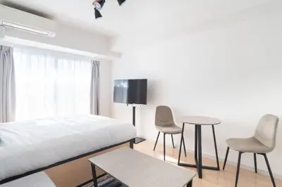 a bedroom with a bed and a table and chairs at \u30ec\u30b8\u30c7\u30a3\u30a2\u4e2d\u843d\u5408b in Tokyo